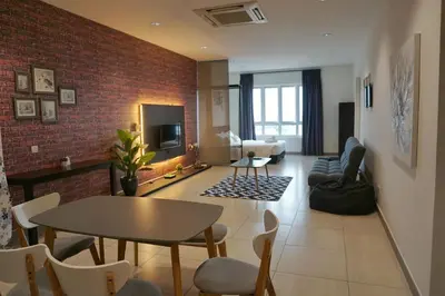 a living room with a table and a brick wall at PM Octagon Ipoh Suites & Apartment 3 in Ipoh