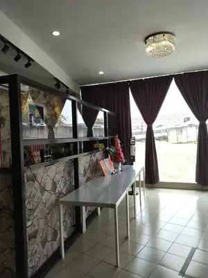 a dining room with a table and purple curtains at Sp Central Hotel in Sungai Petani