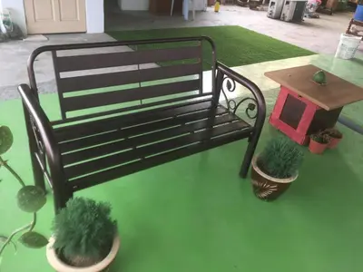 a bench and two potted plants and a table at Anderson Hotel in Ipoh