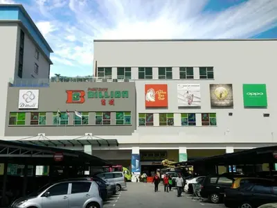 a building with cars parked in a parking lot at Homestay Amsyarah in Seri Iskandar