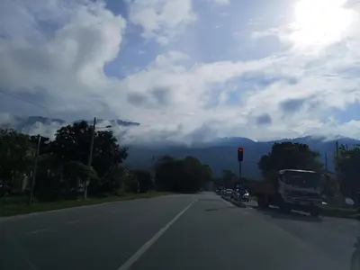 a truck driving down a road with a traffic light at Kelly Cozy cottage in Kampar