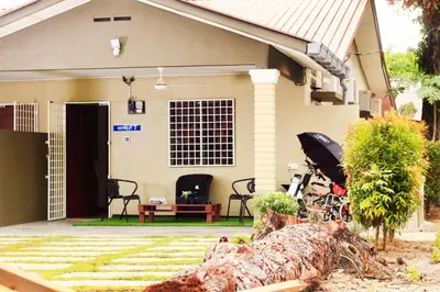 a house with a fallen tree in front of it at The Retreat Homestay in Tanjung Malim