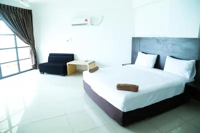 a bedroom with a large white bed and a chair at Marina Heights Resort in Lumut