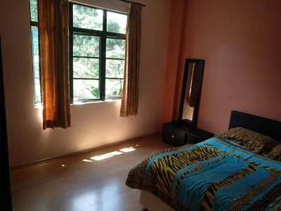 a bedroom with a bed and a mirror and a window at Tenggafriz holidays in Cameron Highlands