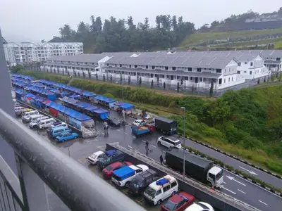 a parking lot with cars parked in front of a building at NAUFAL MUSLIM'S HOMESTAY in Cameron Highlands