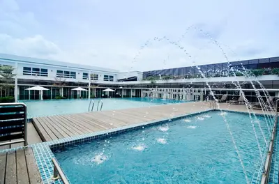 a pool with a fountain in front of a building at Hotel Sfera in Lumut