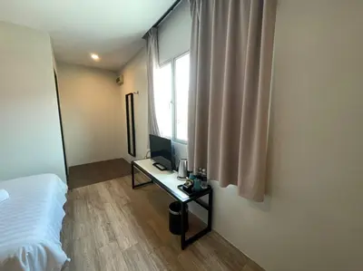 a bedroom with a bed and a desk with a computer at Chariton Hotel Butterworth in Butterworth