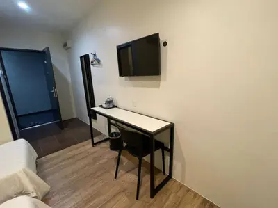a room with a table and a television on a wall at Chariton Hotel Butterworth in Butterworth