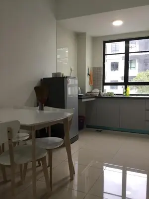 a kitchen with a table and chairs and a refrigerator at The Meadow Park in Kampar