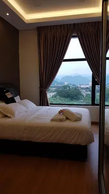 a bedroom with two beds and a large window at Oasis Condominium in Ipoh