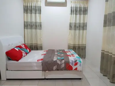 a white bed in a room with curtains at Big Garden Homestay in Pantai Remis