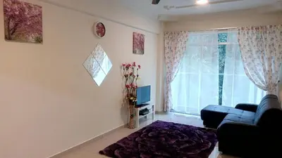 a living room with a blue couch and a window at Azizi&Yati Muslim Homestay Cameron Highlands in Cameron Highlands