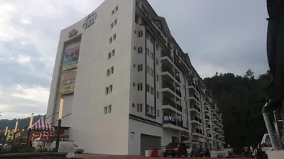 a white building with a sign on the side of it at Peony Square Residences in Cameron Highlands