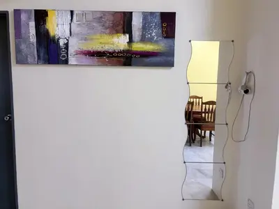 a painting hanging on a wall next to a dining room at Leisure Homestay in Kampong Peruntun