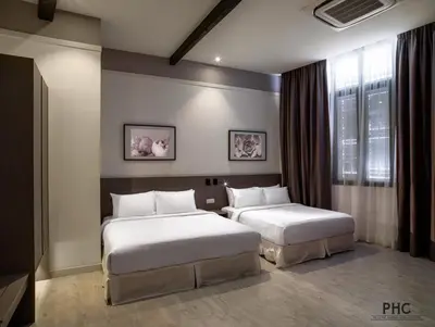 a bedroom with two beds and a window at Hutton Central Hotel Managed by The Ascott Limited in George Town
