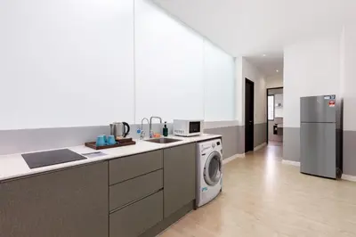 a kitchen with a washer and a washing machine at Hutton Central Hotel Managed by The Ascott Limited in George Town