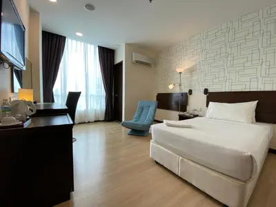 a hotel room with a large bed and a desk at De' Garden Hotel, Butterworth in Butterworth