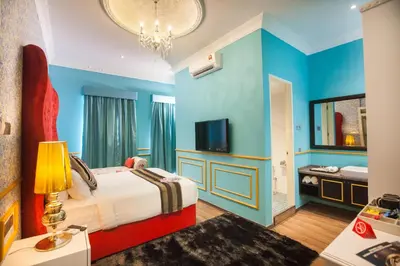 a hotel room with a bed and a tv at Apple Heritage Hotel in George Town