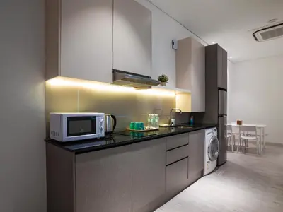 a kitchen with a microwave and a washer at Magazine Vista Hotel Managed by The Ascott Limited in George Town