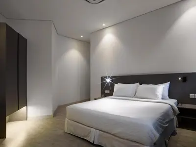 a bedroom with a large bed with white sheets at Magazine Vista Hotel Managed by The Ascott Limited in George Town