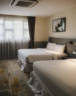 a hotel room with two beds and a window at Magazine Vista Hotel Managed by The Ascott Limited in George Town