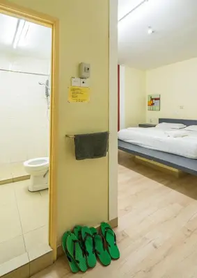 a room with a bed and a pair of green shoes at Abby by the river in Ipoh