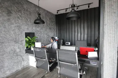 a woman sitting at a desk with a laptop at 68 Boutique Hotel in Sitiawan