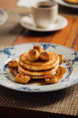a plate with a stack of pancakes on a table at Campbell House in George Town