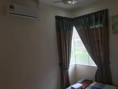 a bedroom with a bed and a window with curtains at Miker Homestay in Seri Iskandar
