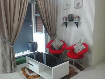 a living room with two red chairs and a entertainment center at Miker Homestay in Seri Iskandar