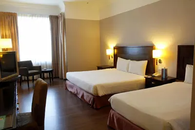 a hotel room with two beds and a television at Grand Kampar Hotel in Kampar