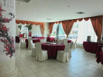 a banquet hall with red tables and white chairs at Grand Kampar Hotel in Kampar