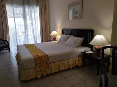 a bedroom with a bed with two lamps and a window at The Orient Star Resort Lumut in Lumut