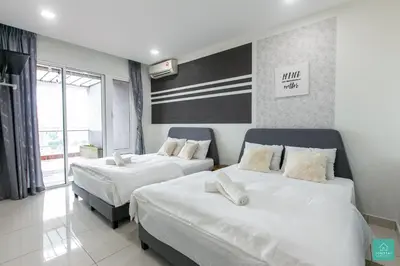 two beds in a hotel room with white sheets at JOMSTAY Octagon Ipoh Suites in Ipoh