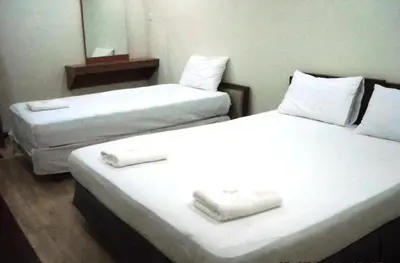 two twin beds in a room with a mirror at Hotel Sri Malim Sungkai in Sungkai