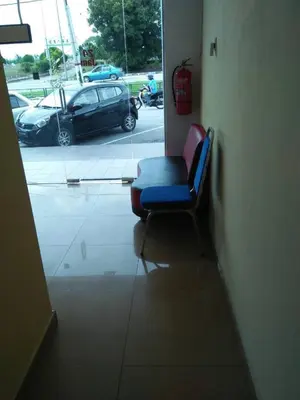 a blue chair in a room with a parking lot at Hotel Sri Malim Sungkai in Sungkai