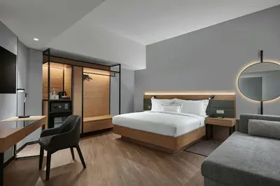 a bedroom with a bed and a desk and a couch at AC Hotel by Marriott Ipoh in Ipoh