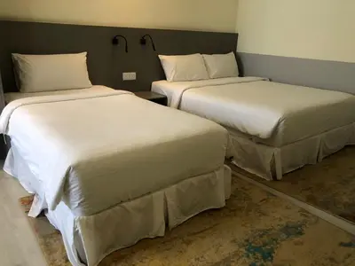 two beds in a hotel room withacers at Hutton Suite Hotel Managed by The Ascott Limited in George Town