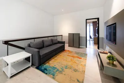 a living room with a couch and a rug at Hutton Suite Hotel Managed by The Ascott Limited in George Town