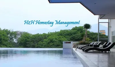 a swimming pool with chairs next to a body of water at H2H - Nichole Maison - Majestic Ipoh in Ipoh