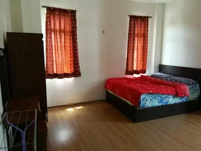 a bedroom with a red bed and two windows at Bzout rents in Cameron Highlands