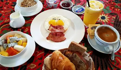 a table with plates of breakfast food and a cup of coffee at Coffee Atelier in George Town