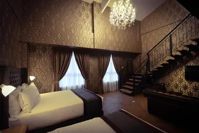 a bedroom with a bed and a staircase and a chandelier at 1969 Business Suites Bandar Botani, Ipoh in Ipoh
