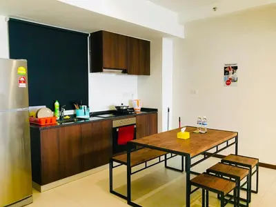 a kitchen with a table and a kitchen with a refrigerator at The Landmark by Katana in George Town