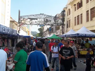 a group of people walking through a street market at D Eastern Hotel in Ipoh
