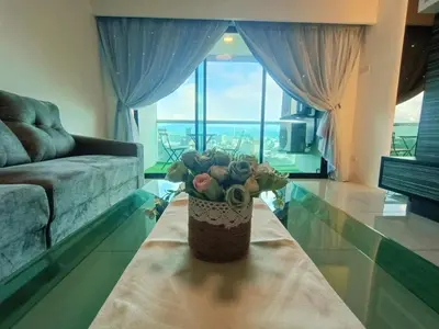 a vase of flowers on a table in a living room at K. Riverfront apartment in Ipoh