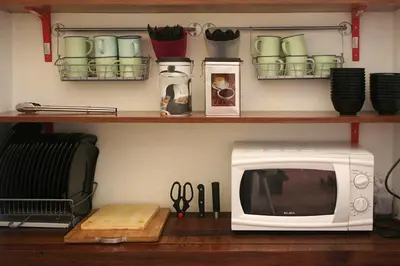 a microwave sitting on top of a wooden table at Red Inn Court in George Town