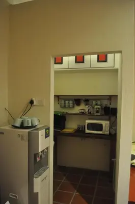 a small kitchen with a refrigerator and a microwave at Red Inn Court in George Town