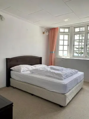 a bedroom with a large bed with white sheets at Habitat Fraser's Hill in Bukit Fraser