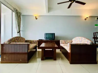 a living room with two couches and a table with a tv at Habitat Fraser's Hill in Bukit Fraser